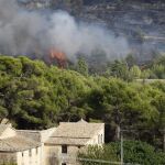 Llamas cerca de unas casas en el incendio declarado hoy en la partida de Rabosina, en el término municipal de La Torre de les Maçanes (Alicante)