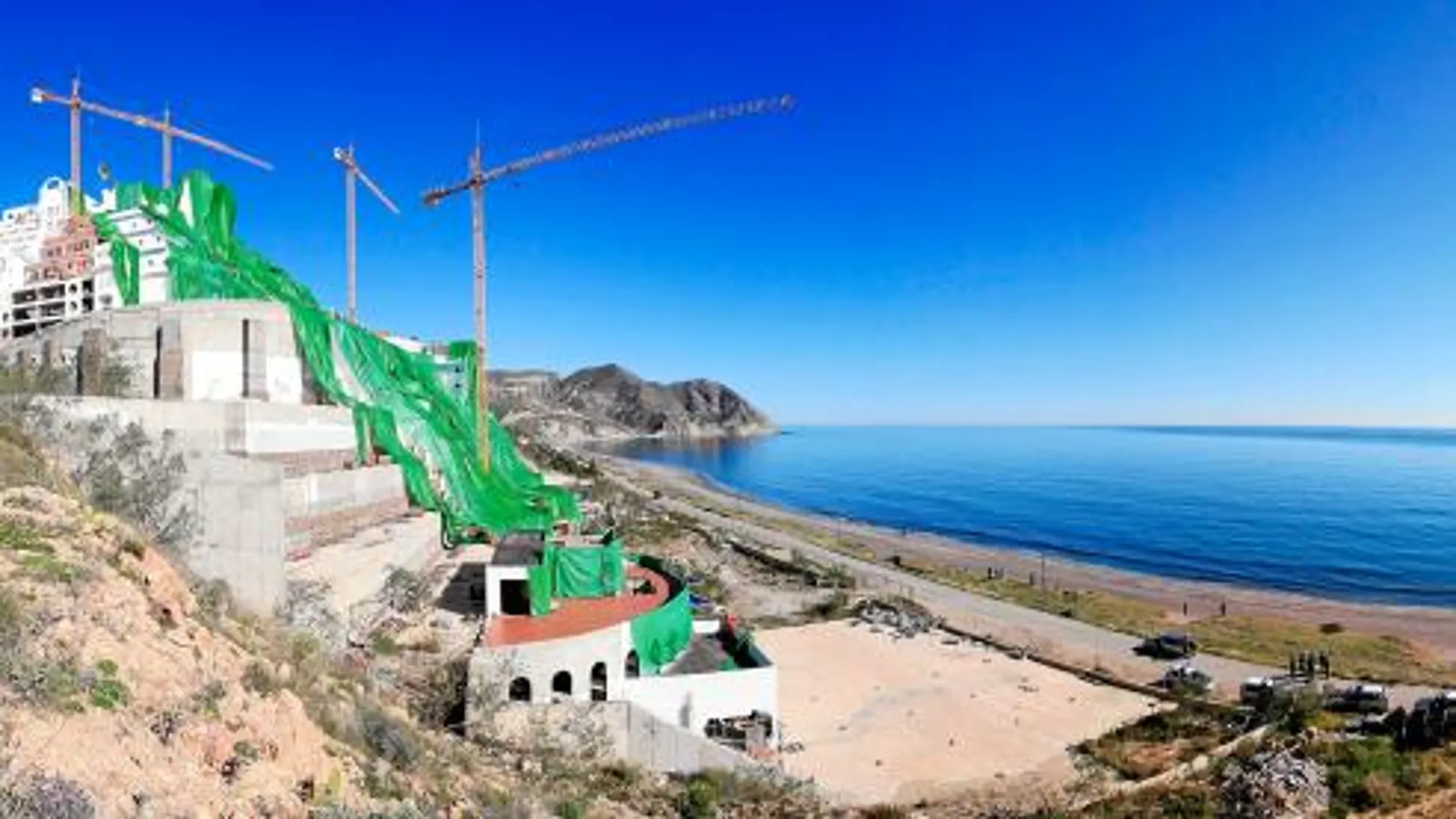 Imagen de El Algarrobico cubierto con una tela verde por Greenpeace