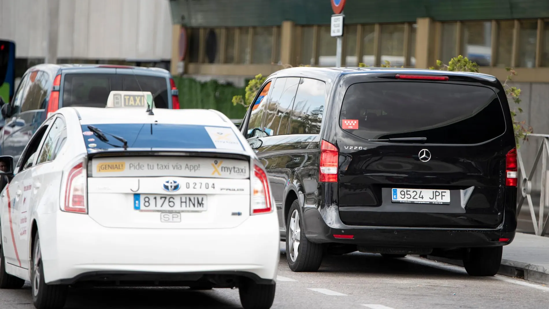 Un taxi y un vehículo VTC en el aeropuerto de Madrid
