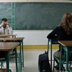Un profesor y una alumna en un aula de clase