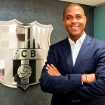 Patrick Kluivert posa, delante del escudo del FC Barcelona, como nuevo director de la cantera