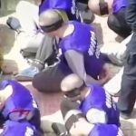 Imagen de los uigures arrodillados en el suelo, con la cabeza rapada y los ojos vendados