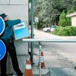 Una agente de la Guardia Civil coloca el cartel de cerrado en la valla de entrada de los coches en el Valle de los Caídos ayer por la tarde. Foto: Europa Press