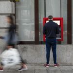 Un hombre saca dinero en un cajero automático