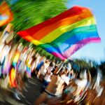 Un joven ondea la bandera del Orgullo en Madrid