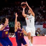 El base argentino del Real Madrid Facundo Campazzo (d) lanza a canasta perseguido por el canadiense Kevin Pangos, del FC Barcelona Lassa, durante el primer partido de la final de la Liga ACB
