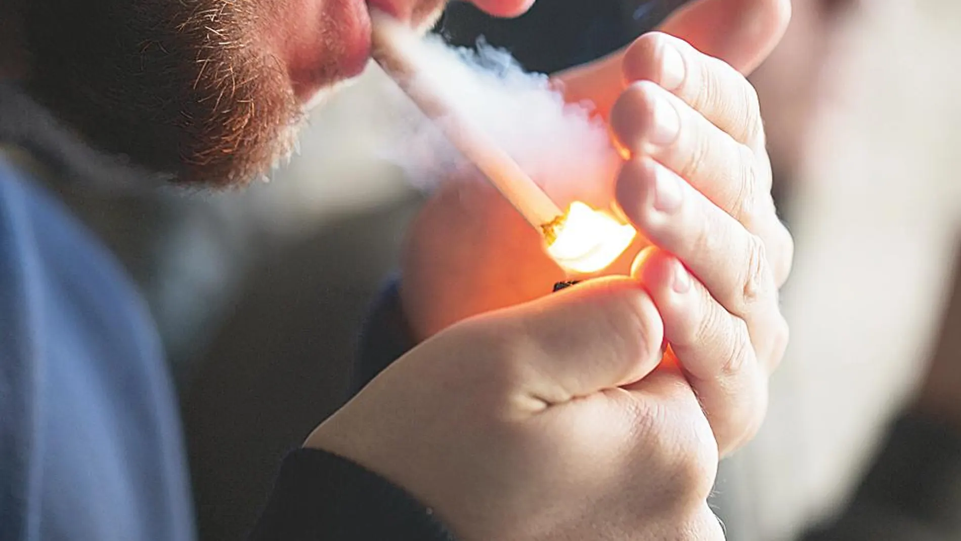 Imagen de un hombre encendiendo un cigarro