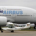Una avioneta pasa por delante de un Airbus A-380