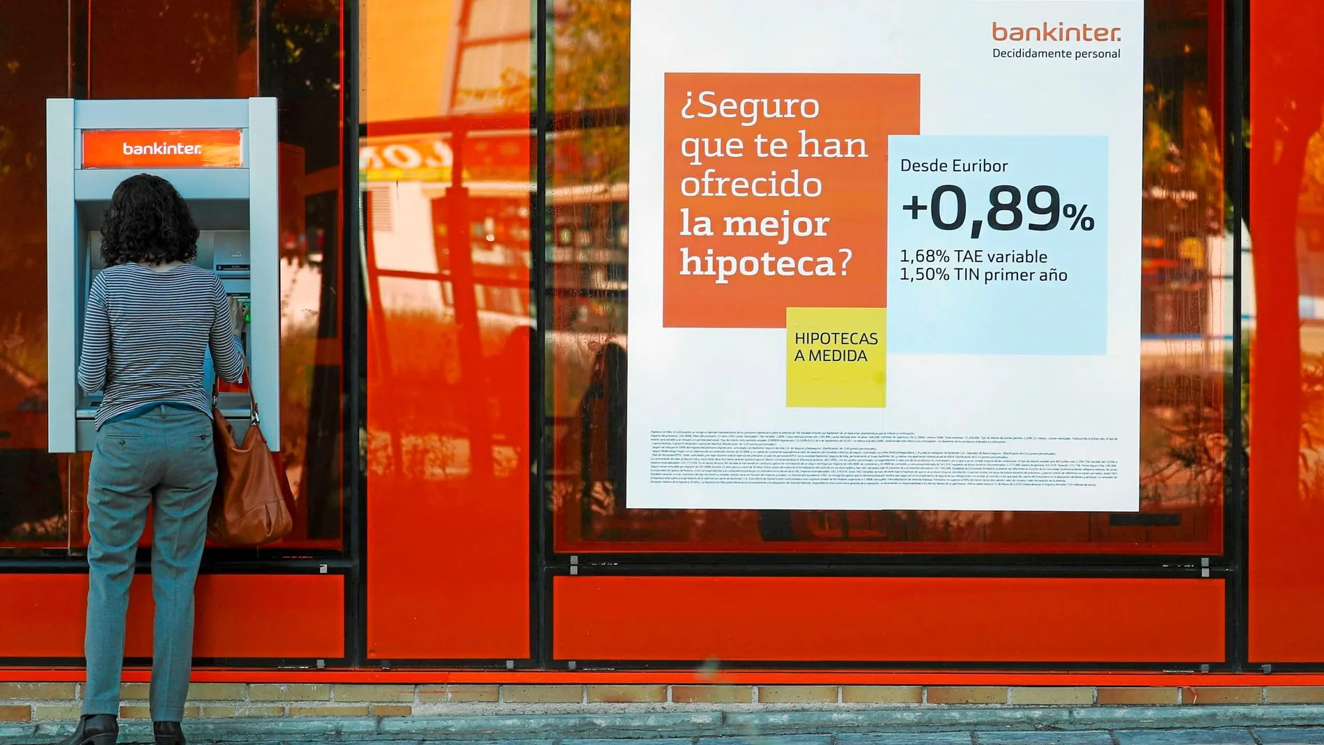 Una persona sacando dinero de un cajero de Bankinter