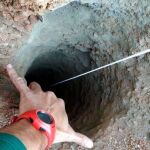 Un guardia civil señala el orificio, de apenas 30 centímetros de ancho, del pozo de más de 100 metros de profundidad por el que cayó Julen