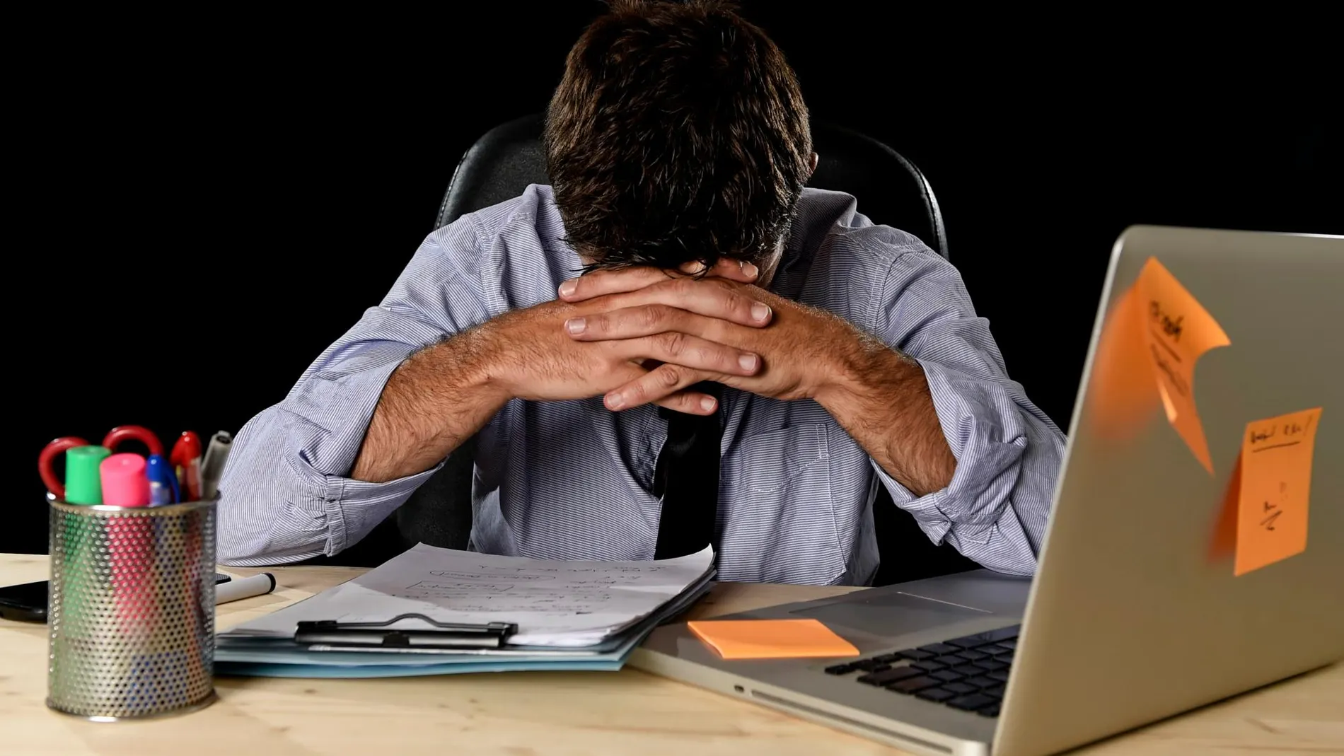 Una persona con estrés laboral en su trabajo