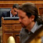 El presidente del Gobierno en funciones, Pedro Sánchez, al fondo y Pablo Iglesias en primer plano. Foto: Efe