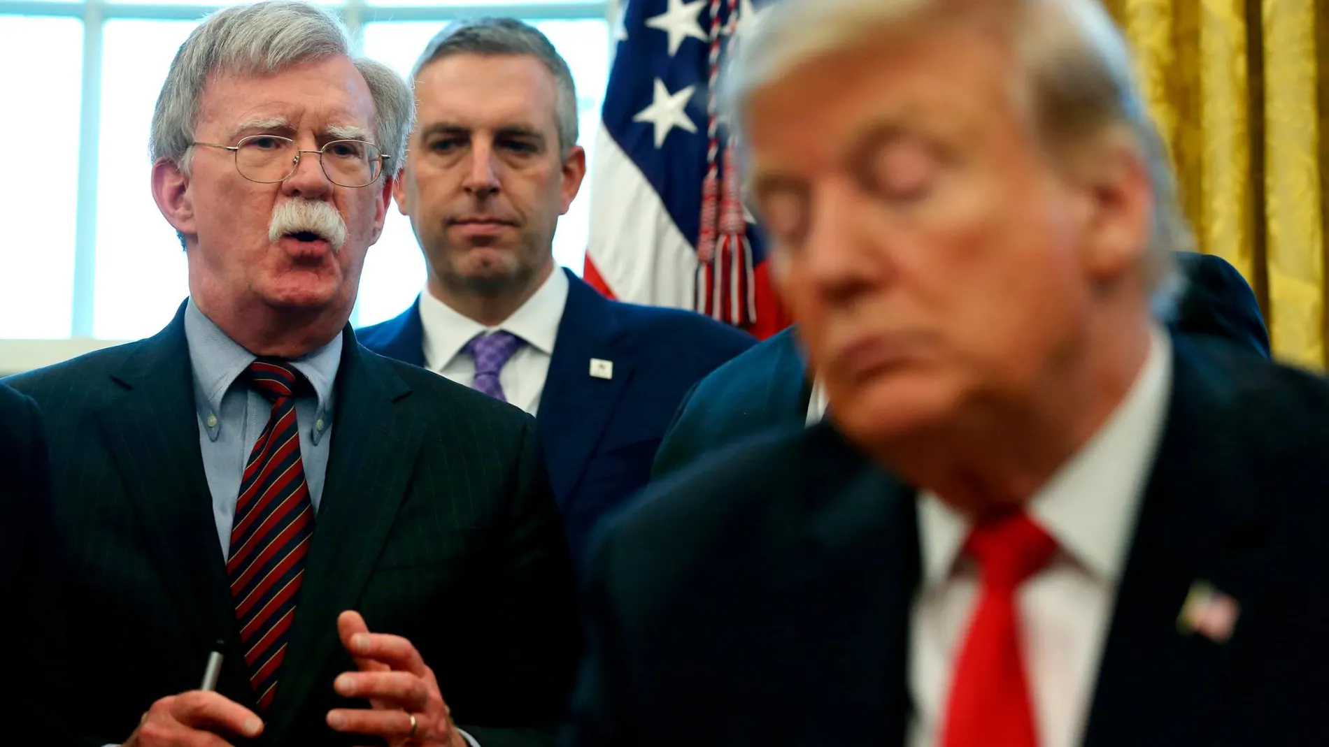 Donald Trump escucha a su ya excolaborador John Bolton en el Despacho Oval