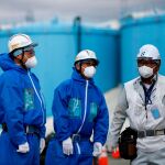 Imagen de varios obreros frente a la fábrica de Fukushima