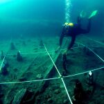Uno de los arqueólogos extrae del fondo del lago los restos de este yacimiento