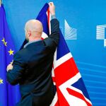Un funcionario ajusta la enseña británica ayer en Bruselas momentos antes de la rueda de prensa de Boris Johnson con el presidente de la Comisión Europea, Jean-Claude Juncker