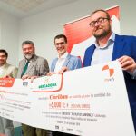 Ernesto Monsalve, Francisco Temprano, Luis Miguel Rojo y Julio Casado posan con el cheque del dinero recaudado