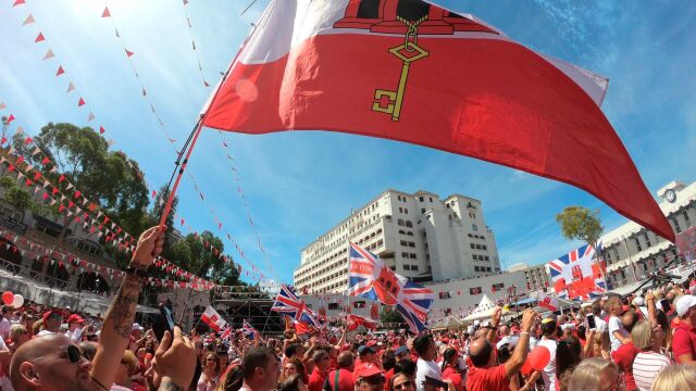 Ciudadanos ondeando banderas en el acto político de la celebración del Día Nacional de Gibraltar
