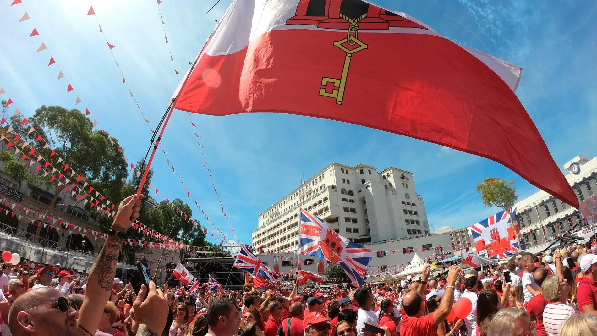 Ciudadanos ondeando banderas en el acto político de la celebración del Día Nacional de Gibraltar