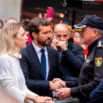 Pablo Casado y Cayetana Álvarez de Toledo saludan a un agente de la Policía Nacional en la calle junto a la puerta de la Jefatura Superior de la Policía Nacional/Foto: Efe