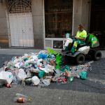 Un operario de limpieza recoge basura en una calle de Chueca hoy domingo. (Fotos: Jesús G. Feria)