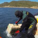 Momento en que los GEAS de la Guardia Civil sacan los fardos de droga del agua