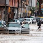 Voluntarios de protección civil trasladan a un hombre en silla de ruedas tras las intensas lluvias esta tarde en el barrio de Runes, Blanca