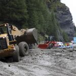 Las máquinas tratan de limpiar la carretera llena de barro