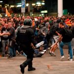 Un mosso durante una de las cargas contra las miles de personas se agolpan ante el Aeropuerto del Prat. EFE/Toni Albir