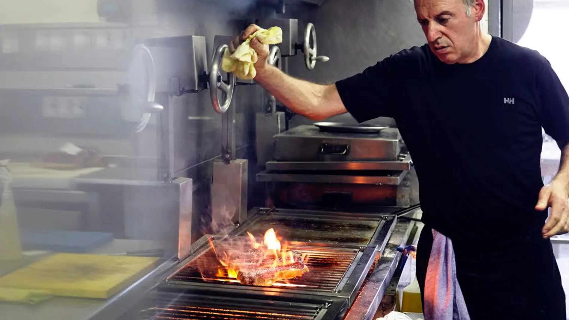 El cocinero Victor Arguinzoniz, junto a las brasas, mientras elabora uno de sus grandes platos ©ASADOR ETXEBARRI