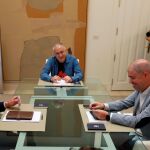 El presidente del Gobiero, Pedro Sánchez, con el líder de UGT, Pepe Álvarez, al fondo, y el de CC OO, Unai Sordo, en La Moncloa
