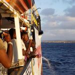 Varios migrantes lavándose los dientes en el Open Arms