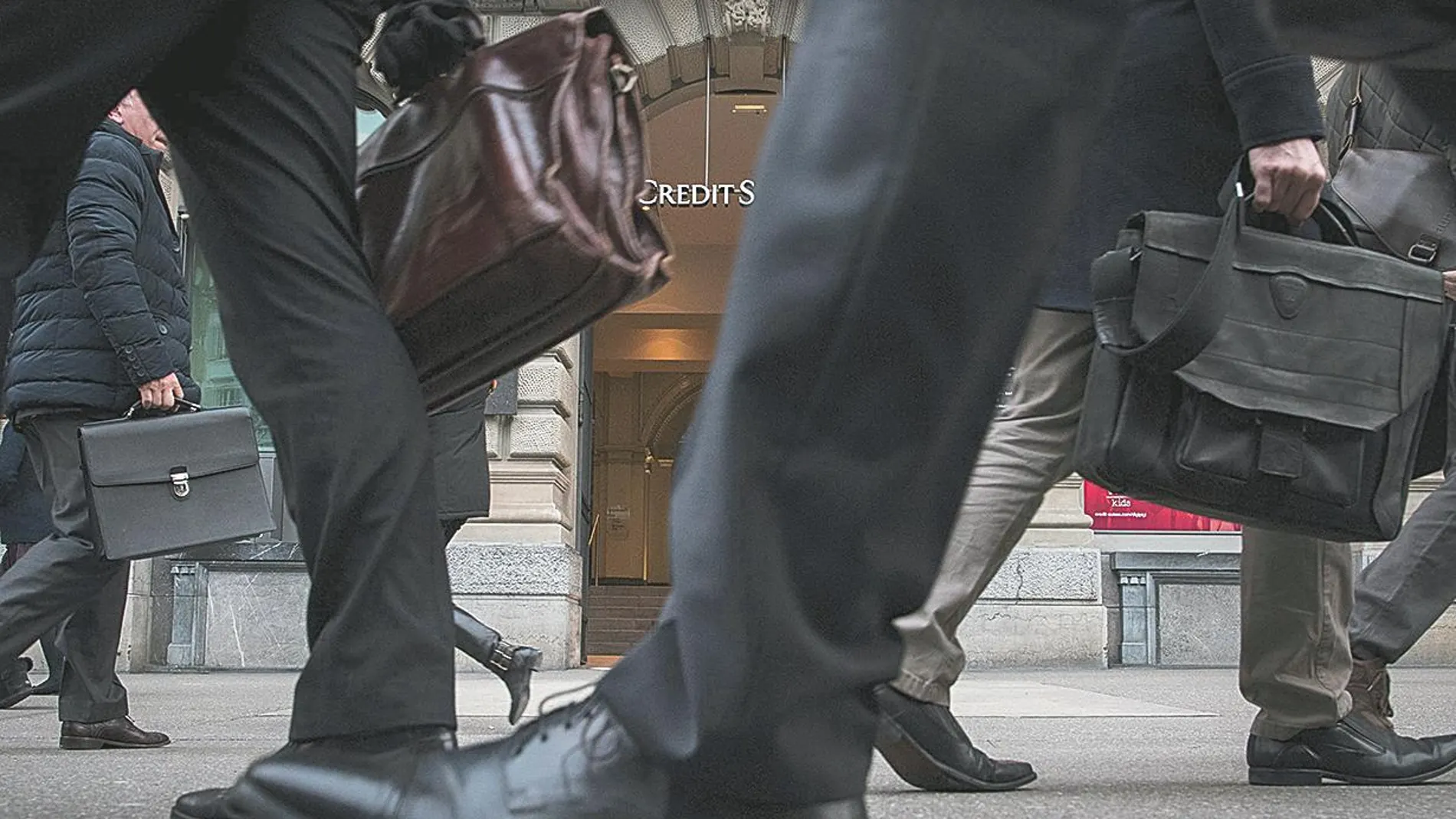 Varios viandantes pasan frente a una entidad financiera suiza en la ciudad de Zúrich