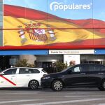 Un taxi y un vehículo VTC circulan por una céntrica calle madrileña