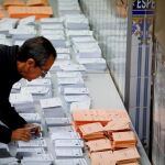 Un hombre busca entre las papeletas de los diferentes formaciones políticas. Foto: Efe