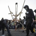 Los manifestantes terminan su catapulta, en el puente en el que se han atrincherado