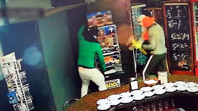 Dos delincuentes asaltando un comercio