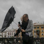 Una racha de viento desbarata el paragüas de una viandante