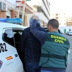 Un agente de la Guardia Civil con uno de los detenidos en Mazarrón por trata de personas