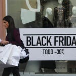 Una mujer pasa por delante del escaparate de una tienda durante la jornada del "Black Friday"
