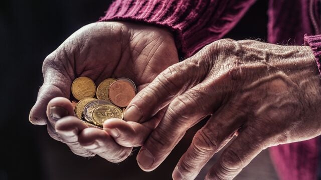 Monedas en las manos de una persona mayor
