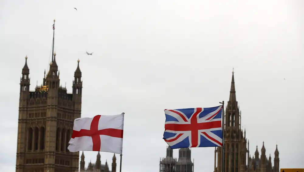 Una bandera inglesa y otra británica ondean frente al palacio de Westminster en Londres. (AP Photo/Thanassis Stavrakis)