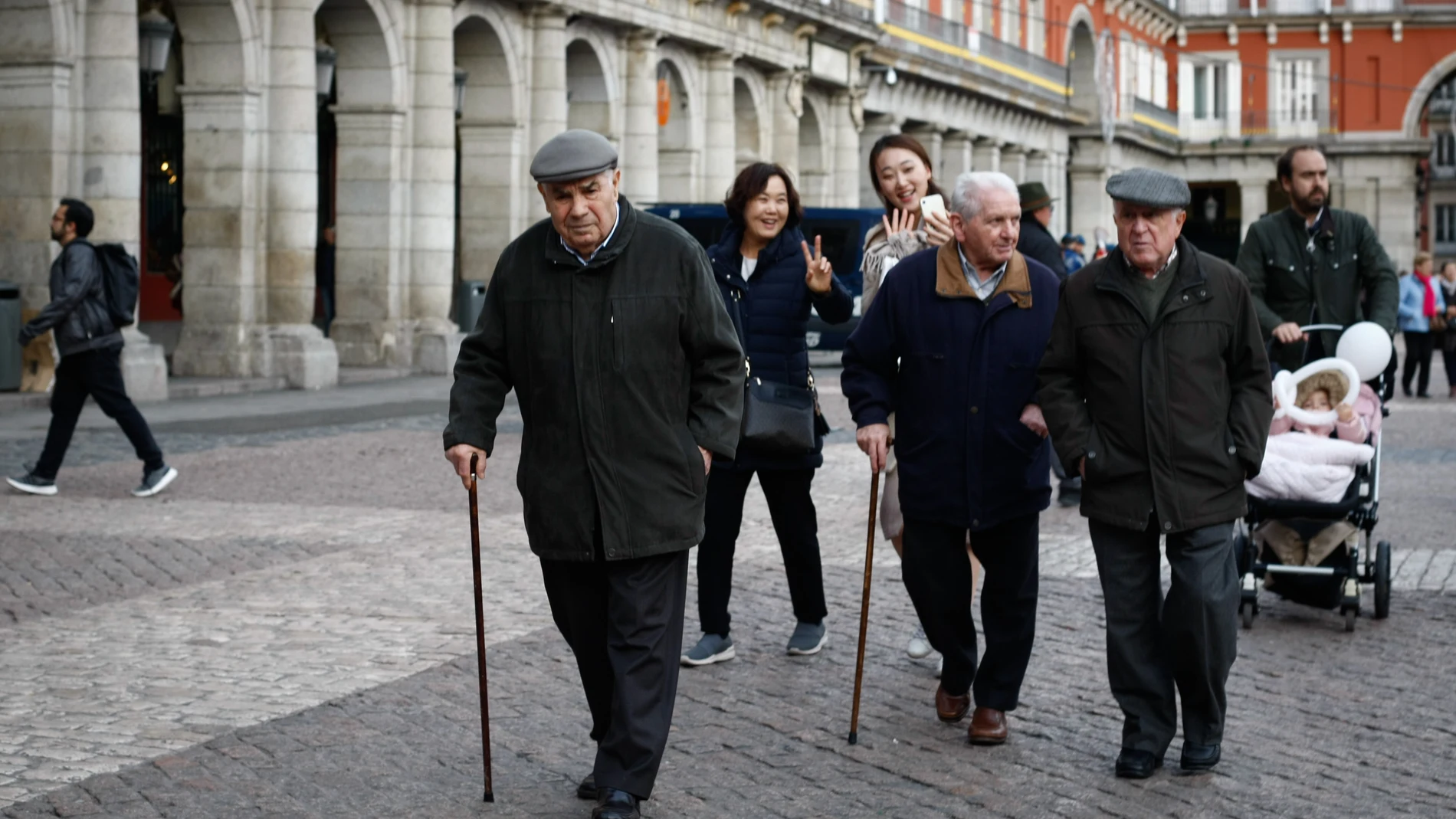 Ancianos pasean por la plaza mayor de Madrid