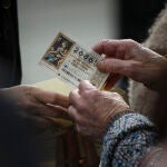Personas guardando un décimo de lotería en un sobre. En Sevilla, a 17 de diciembre de 2019.SEVILLA, 17. 12.19. Ventas de lotería de Navidad 2019.María José López / Europa Press17/12/2019