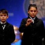 Los niños del colegio de San ildefonso Nerea pareja y Luis Alcides muestran las bolas con el número 41.710 que ha sido agraciado con el primero de los dos cuartos premios, dotados con 200.000 euros a la serie (20.000 euros al décimo), en el Sorteo Extraordinario de la Lotería de Navidad que se celebra este domingo en Madrid. EFE/J.J. Guillén