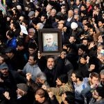 Un manifestante alza un retrato del difunto comandante de la Fuerza Quds de los Guardianes de la Revolución de Irán, Qasem Soleimaní, durante una protesta multitudinaria contra EEUU, este viernes en Teherán (Irán). EFE/Abedin Taherkenareh