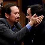 El líder de Unidas Podemos, Pablo Iglesias (i), se abraza con el líder de Izquierda Unida, Alberto Garzón, después de que el candidato socialista Pedro Sánchez lograra este martes la confianza del Congreso para un nuevo mandato como presidente del Gobierno, al lograr una estrecha mayoría de 167 votos a favor, 165 en contra y 18 abstenciones. EFE/ Mariscal