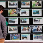 Una persona observa el escaparate de una inmobiliaria