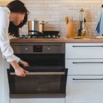 Una mujer hace uso del horno en su vivienda