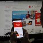 Mujer agarrando su dispositivo móvil con ambas manos y deslizando con un solo pulgar